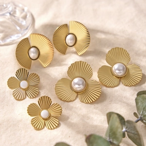 Ensemble de boucles d'oreilles ginkgo et fleurs dorées avec perles sur lin