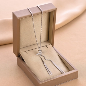Collana in oro rosa con pendenti a triangolo vuoto sopra una scatola da regalo