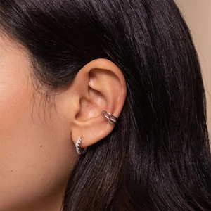 Macro shot of silver sterling earrings set with pavé cubic zirconia on female ear