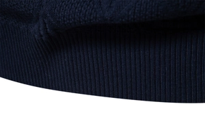 Close-up of the high-quality ribbed hem and navy blue knit texture on this men's sweater