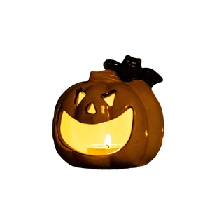 Creative Halloween orange ceramic pumpkin candle holder with a black bat and lit tea light