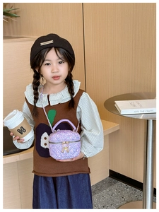 Close-up of a girl carrying a purple sequined quilted handbag with a chain strap