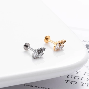 Detailed view of hollow leaf earrings with zircons in silver and gold F136 titanium finish