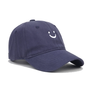 Detail of navy cotton baseball cap with white embroidered smiley face and curved brim