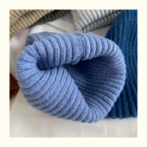 Close-up of thick ribbed knit beanies in various colors including blue and grey