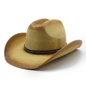 Close-up of a straw cowboy hat featuring a leather band with golden metal rivets