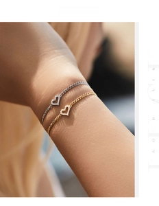 Close-up of gold and silver heart bracelets with small diamonds on Cuba chain for women