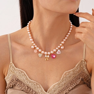 Collier ras du cou en perles roses avec pendentifs cœur brillant et nœud doré chic