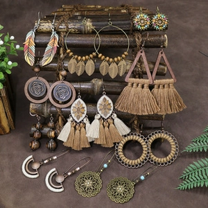 Detail view of assorted bohemian earrings with feathers, tassels and wood hanging on display