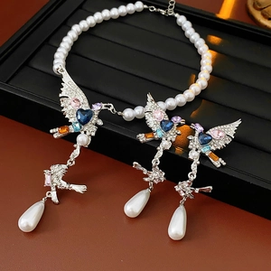 Détail d'un ensemble de bijoux vintage avec oiseaux, perles et cristaux colorés