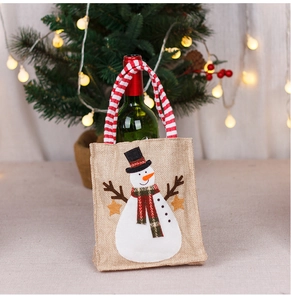 Christmas burlap wine gift bag featuring a snowman applique and festive striped handles