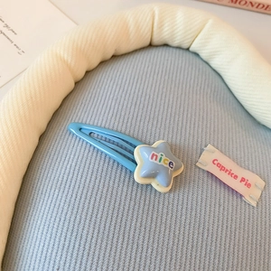 Vue macro d'une barrette étoile bleue avec l'inscription colorée nice pour cheveux