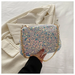 Close-up of white sequin handbag featuring iridescent texture and gold chain strap