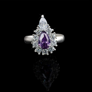 Macro shot of silver ring with pear-cut purple gemstone and sparkling white accents