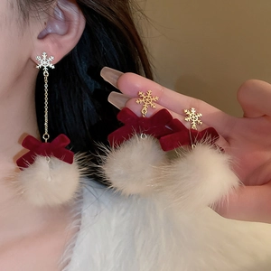 Detail of Christmas bow earrings with gold snowflake, red velvet and white pompom