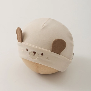 Détail de la broderie ours et des oreilles 3D sur le bonnet en coton pour bébé