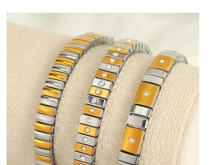 Detail of three two-tone stretch bracelets with rhinestones on a jewelry display pillow