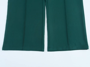 Detail of the hem on dark green straight-leg trousers with clean stitching