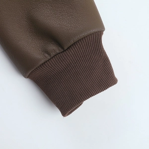 Macro detail of dark brown PU leather sleeve with elastic ribbed cuffs on a winter jacket