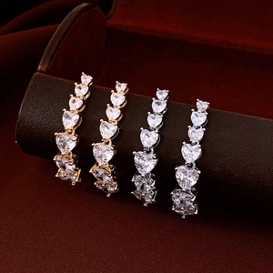 Macro view of gold and silver plated earrings with vertical gradient heart-shaped crystals