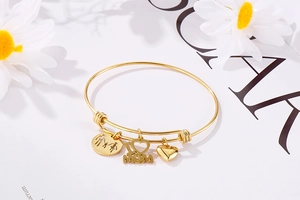 Detail of adjustable gold bangle with Mother's Day charms and family silhouette