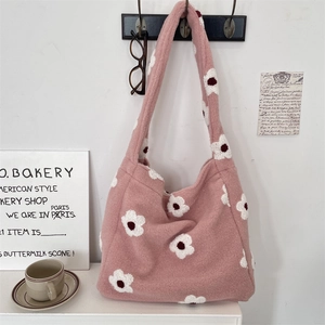 Dettaglio della borsa tote in pile rosa con motivi floreali bianchi al gancio