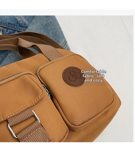 Detailansicht einer braunen Canvas-Tasche mit mehreren Taschen und Nylon-Trageriemen
