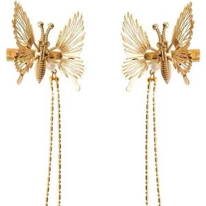 Golden butterfly hair clips with long chain tassels in a symmetrical flat lay view