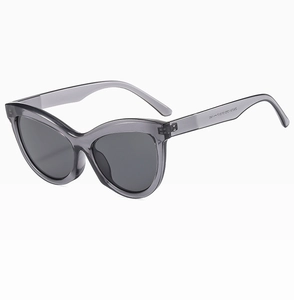 Close-up of translucent grey cat-eye sunglasses with detailed specifications on temple