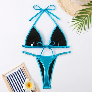 Détail d'un bikini bleu métallisé avec haut dos nu et anneaux métalliques pour un look balnéaire
