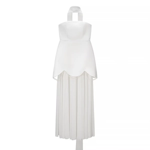 Detailed view of white halter dress featuring ruffle bodice and elegant pearl bead accents