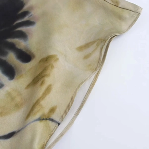 Detailed view of women's dress hem featuring elegant brown and black printed satin fabric