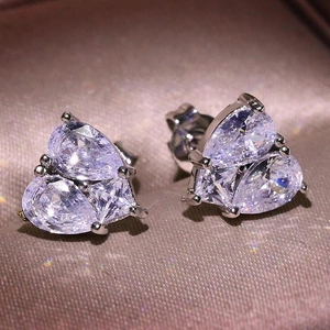 Macro shot of silver heart-shaped stud earrings featuring triple pear-cut zircon stones