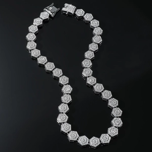 Macro view of iced-out geometric link chain with pave-set diamonds on black background
