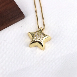 Macro shot of gold star-shaped pendant featuring a zircon-encrusted letter M on box chain