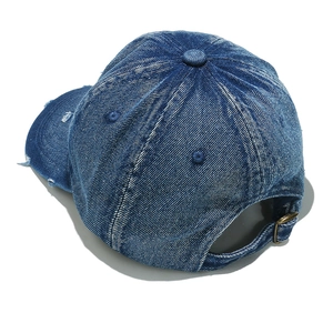 Close-up of distressed denim baseball cap with vintage wash and adjustable metal buckle