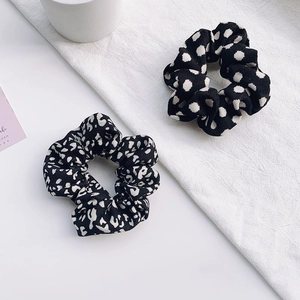 Détail de chouchous à pois noirs et blancs et imprimé léopard sur fond blanc pur