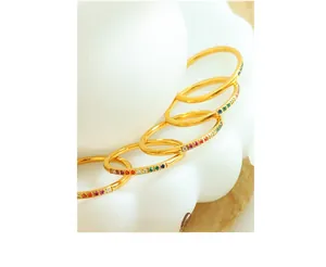 Macro view of five rainbow zircon gold rings stacked on a minimalist white display