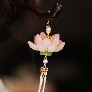 Dettaglio di un fermaglio per capelli a loto con petali rosa ed eleganti nappe di perle