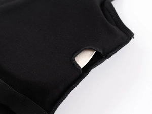 Detail shot of black sports top showing inner breast pad pocket and knitted fabric texture