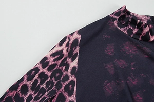 Detail of high collar and pink leopard print pattern on dark blue stretch fabric