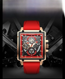 Macro detail of square gold skeleton watch face with red silicone strap and chronograph dial