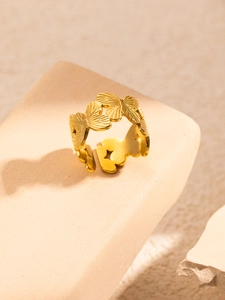 Macro detail of a golden butterfly ring featuring textured wings and an adjustable band