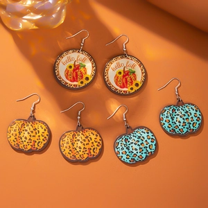 Three pairs of pumpkin earrings with leopard prints and hello fall text for autumn style