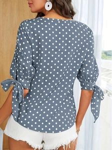 Blauwe polkadot damesblouse met strikmanchetten en een ronde hals, achteraanzicht model