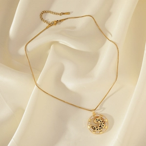 Gold leopard pendant necklace with zircon stones and black enamel spots on silk background