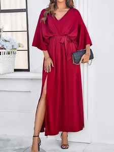 Detail of elegant wine red dress featuring a V-neck, waist tie and side slit detail