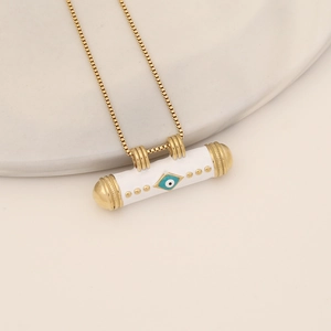 Detailed close-up of a white enamel devil eye pendant on a fine gold-tone chain necklace