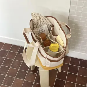 Detailed interior of a canvas diaper bag showing organized bottles and snacks