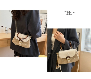 Detail view of woven straw handbag with flower embroidery and natural bamboo handle